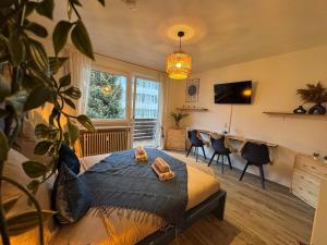 a bedroom with a bed and a desk with chairs at BOHO Apartment Zirbe Blue in Bad Reichenhall