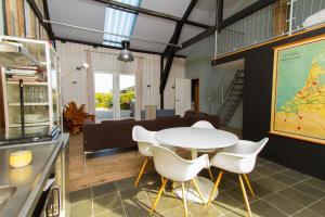 a dining room with a white table and white chairs at Paardenstal, Private House with wifi and free parking for 1 car in Weesp