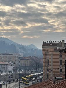 eine Stadt mit Gebäuden und einem gelben Bus in der Unterkunft Old Town's Fairytale in Sarajevo