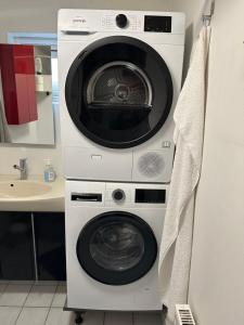 a washing machine and a dryer in a bathroom at Fasan sleeping in Esbjerg +1 photo
