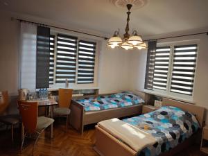 a bedroom with two beds and a table with chairs at Dom Lawendowy in Lubasz