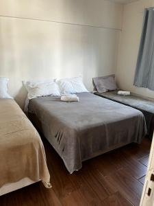 two beds in a small room with wooden floors at POUSADA BLUE GARDEN in Lages +73 photos