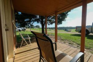a porch with two chairs and a truck in a field at That 70s Cabin Yellow Rose Canyon in Mount Enterprise