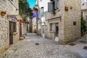 an alley in an old town with stone buildings at House Morski brk in Trogir