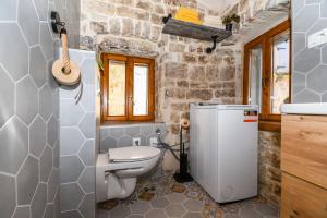 a small bathroom with a toilet and a sink at House Morski brk in Trogir +14 photos