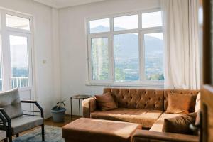 ein Wohnzimmer mit einer Couch und zwei Fenstern in der Unterkunft Cozy Mountain View House Near Olympos & Adrasan in Kumluca