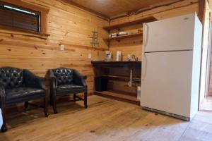 a living room with a refrigerator and two chairs at Barn 1 Yellow Rose Canyon in Mount Enterprise