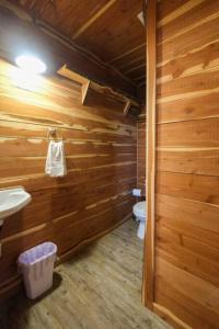 a bathroom with wooden walls and a toilet and a sink at Barn 1 Yellow Rose Canyon in Mount Enterprise