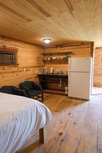 a bedroom with a white refrigerator and a desk at Barn 1 Yellow Rose Canyon in Mount Enterprise