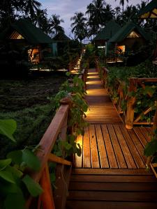 a wooden walkway with plants on it at night at Jenené Lodge Nuquí in Nuquí +47 photos