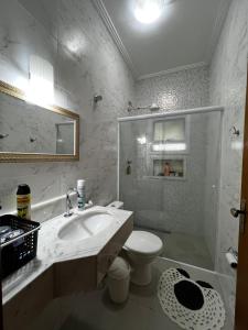 a bathroom with a sink and a toilet and a shower at Casa Santo Sossego in Peruíbe