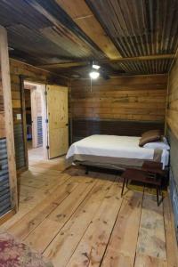 a bedroom with a bed in a wooden room at The Blues House Yellow Rose Canyon in Mount Enterprise