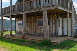 a large wooden house with a porch and a tv at Barn 2 Yellow Rose Canyon in Mount Enterprise