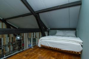 a small bed in a room with a ceiling at Paardenstal, Private House with wifi and free parking for 1 car in Weesp