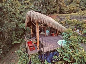 a hut with a deck with chairs and a pool at BOSQUE SECRETO Ecolodge in Pereira