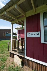 a red house with a sign that reads reinicked at Redwood Cabin Yellow Rose Canyon in Mount Enterprise