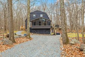 una casa nel bosco con un vialetto di ghiaia di Pocono Luxury Retreat - Games Hot tub and More a East Stroudsburg
