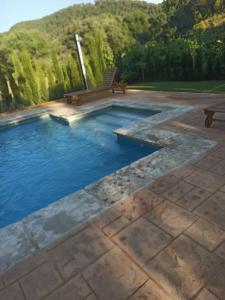 a swimming pool with a bench on a patio at Casa Rural Majana II in Riópar