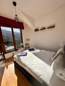 a bedroom with a large bed and a large window at PM Services Semiramida Apartments in Borovets +122 photos