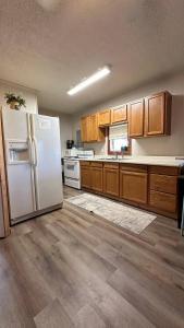 a kitchen with a white refrigerator and wooden cabinets at Redwood Cabin Yellow Rose Canyon in Mount Enterprise
