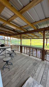 a porch with tables and chairs on a wooden deck at Redwood Cabin Yellow Rose Canyon in Mount Enterprise