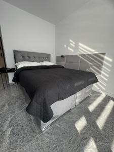 ein Bett mit einer schwarzen Bettdecke in einem Schlafzimmer in der Unterkunft NEW -Sweet Dreams -Na uboczu Centrum -PARKOWE WZGÓRZE -Garaż Podziemny-f VAT in Kielce + 34 Fotos