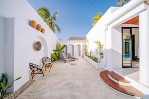 an outdoor patio of a house with chairs and tables at Marram Villas Prime Location in Paje
