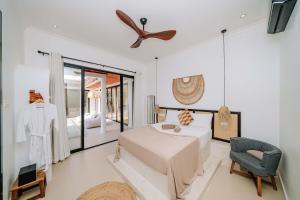 a bedroom with a bed and a ceiling fan at Marram Villas Prime Location in Paje