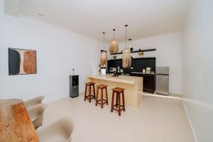 a kitchen with a counter and some stools at Marram Villas Prime Location in Paje