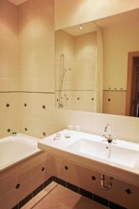 W łazience znajduje się umywalka, wanna i lustro. w obiekcie Hotel-Gasthof Weitgasser w mieście Mauterndorf +20 zdjęć