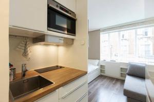 a kitchen with a sink and a microwave at Apartments Craven Terrace in London