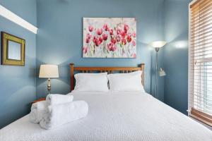 サンアントニオにあるMosaic - A Birdy Vacation Rentalのベッドルーム1室(白いシーツと絵画付)