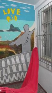 a painting on a wall with a red dress next to a door at Colinna Hostel in Rio de Janeiro +37 photos