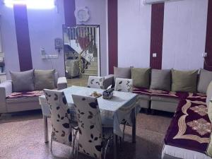 a living room with a table and chairs and a couch at Furit apartment in Mazār Abū ‘Ubaydah