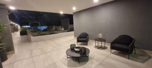 a lobby with two chairs and a table in a building at Equipado y hermoso Departamento in Santiago