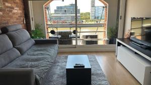 a living room with a couch and a large window at Puente de la Mujer in Buenos Aires