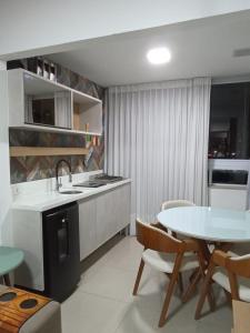 a kitchen with a table and a sink and a table and chairs at Apartamento Praia de Itaparica in Vila Velha