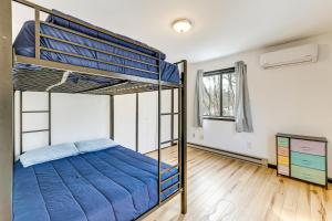 a bedroom with two bunk beds and a wooden floor at Hot Tub and Game Room Long Pond Getaway! in Long Pond
