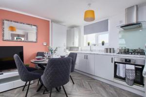 レッドブリッジにあるSleek Gem of London -2 Bedroom Apartment with Parkingの部屋にテーブルと椅子のあるキッチン
