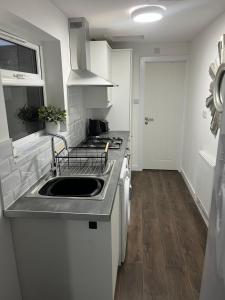 a kitchen with a sink and a stove at Fully Refurbished 3 Bed Terraced House with Ensuite Central Rugby in Rugby +12 photos