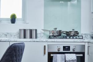 レッドブリッジにあるSleek Gem of London -2 Bedroom Apartment with Parkingのキッチン(鍋、鍋、コンロ付) +1枚の写真