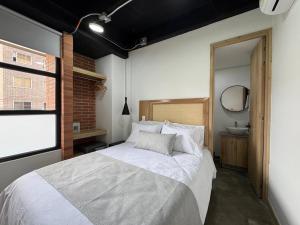 a bedroom with a large bed and a mirror at Akela Park Hotel in Medellín