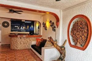 a living room with a couch and a tv at HOTEL VILLAS XAIBA in Puerto Escondido