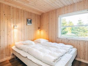 a large bed in a room with a window at 4 star holiday home in Idestrup in Marielyst +33 photos