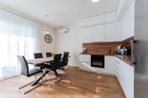 une cuisine avec une table de salle à manger et des chaises noires dans l'établissement Flex SelfCheckIns 143 - Novaki -Terrace - 4 Bedrooms - Parking, à Novaki Samoborski