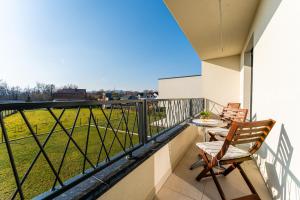 - un balcon avec 2 chaises, une table et un champ dans l'établissement Flex SelfCheckIns 143 - Novaki -Terrace - 4 Bedrooms - Parking, à Novaki Samoborski