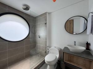 a bathroom with a toilet and a sink and a mirror at Akela Park Hotel in Medellín +23 photos