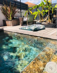 einen Pool mit Kissen auf einer Holzterrasse in der Unterkunft La Dolce Villa - Bali&les Cévennes in Alès