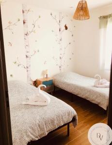 1 Schlafzimmer mit 2 Betten mit Schwänen an der Wand in der Unterkunft La Dolce Villa - Bali&les Cévennes in Alès + 47 Fotos