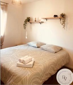ein Schlafzimmer mit einem Bett, auf dem zwei Handtücher liegen in der Unterkunft La Dolce Villa - Bali&les Cévennes in Alès
